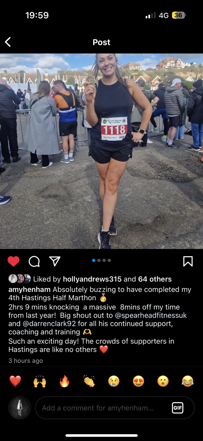 Amy holding her medal after the Hastings Half Marathon.